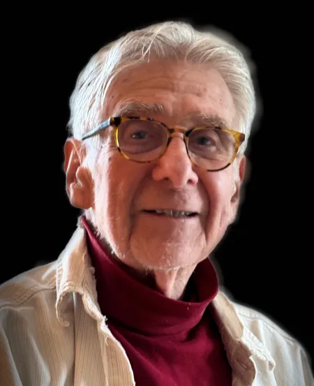 Man wearing glasses in a red turtleneck.