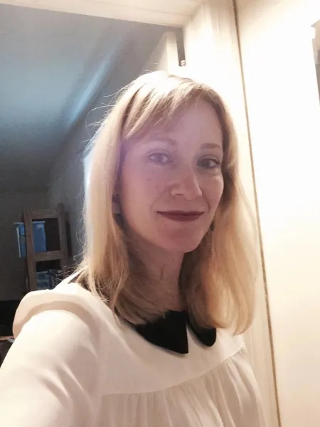 Woman with light hair wearing a white blouse.