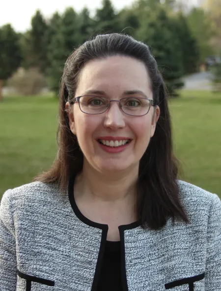 Dark haired woman wearing glasses.