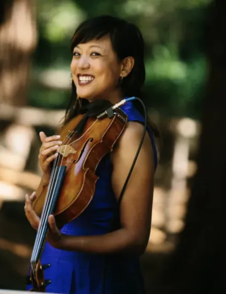 Bora Yoon holding a violin and smiling