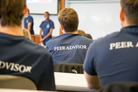 A picture of the backs of three students with the words "peer advisor" on their t-shirts.