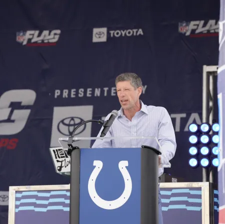 Ithaca College alumnus Brian Flinn ’96, senior vice president of global flag football for the National Football League, stands at a podium. Photo courtesy of the NFL.