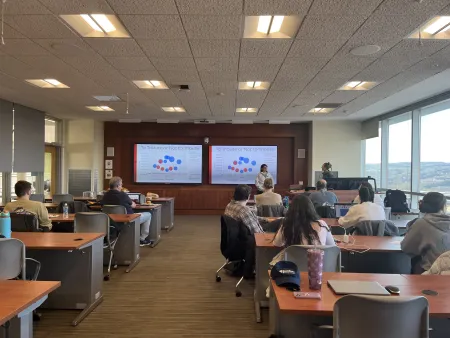 This is a photo of a class with data on the screens in front.