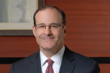 Photo of Marc Weinberg. He is wearing a suit and has glasses.