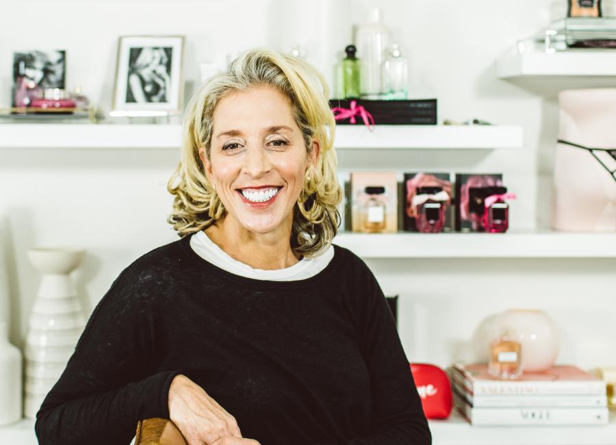 Photographic portrait of Jan Singer smiling in Victoria's Secret office