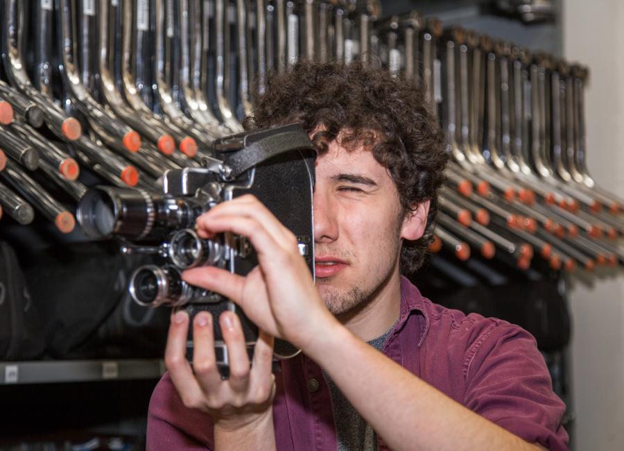 Tyler Macri looks into camera while adjusting lens