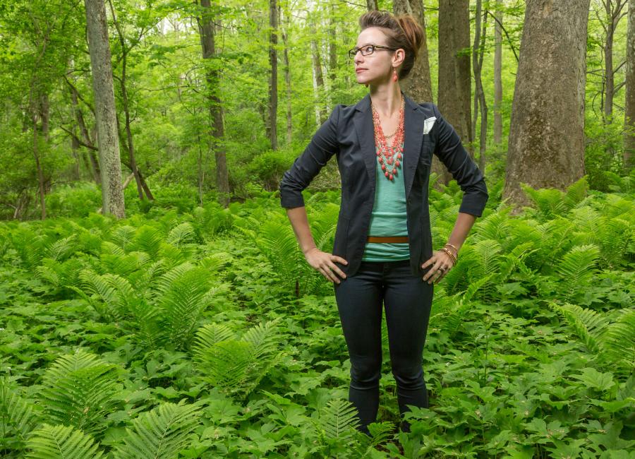 Sarah Brylinsky stands in a lush green forest