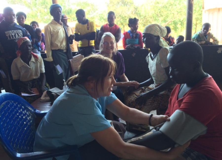 Mary Taylor taking a young man's blood pressure in Malawi.