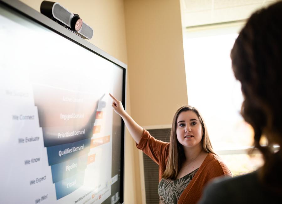 A student makes a presentation in the analytics lab