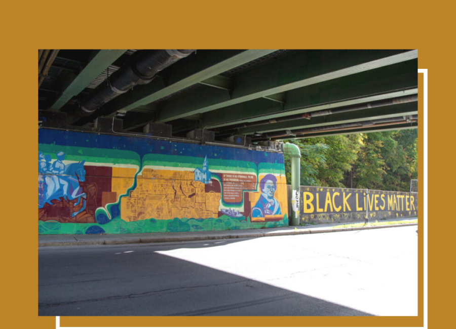 A picture of an underpass with a mural on the far side wall.  The mural has a picture of Fredrick Douglass as well as the words "Black Lives Matter"