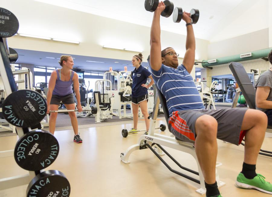 Members using strength equipment on the fitness floor.