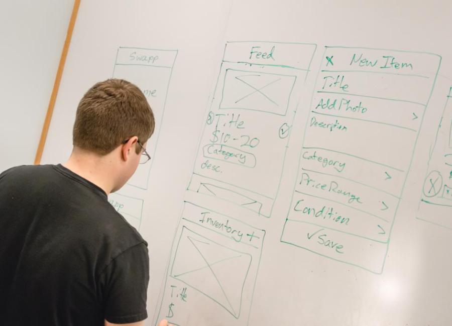 male student writes on a whiteboard