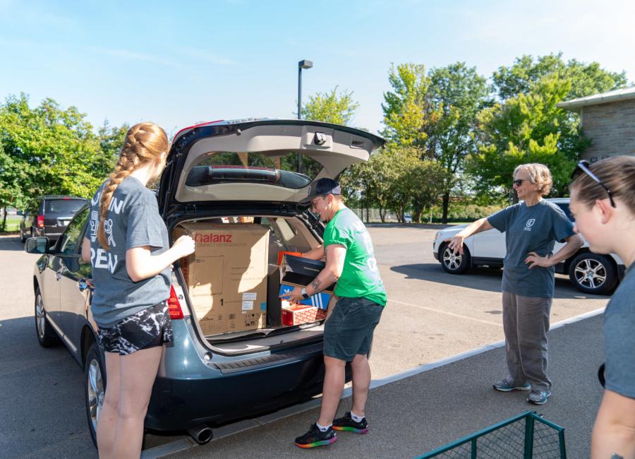 Student unpacking their vehicle, preparing to move in.