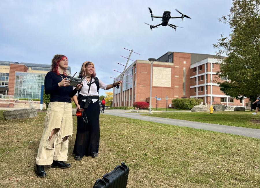 Sierra Dages and Gabriella Hubchen, two physics majors, conduct field work in environmental physics using drones and antennae 