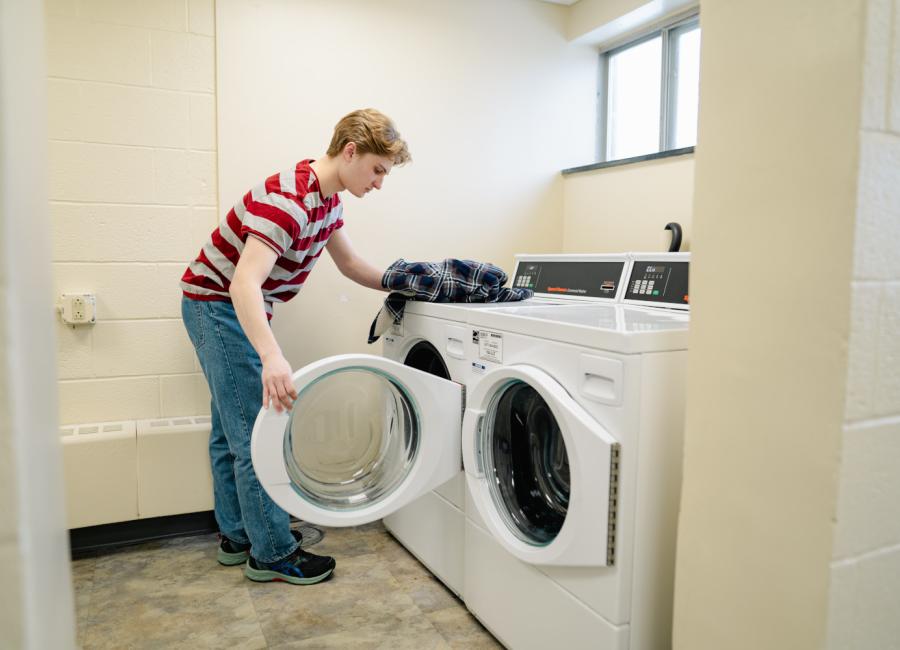 student loading a laundry machine