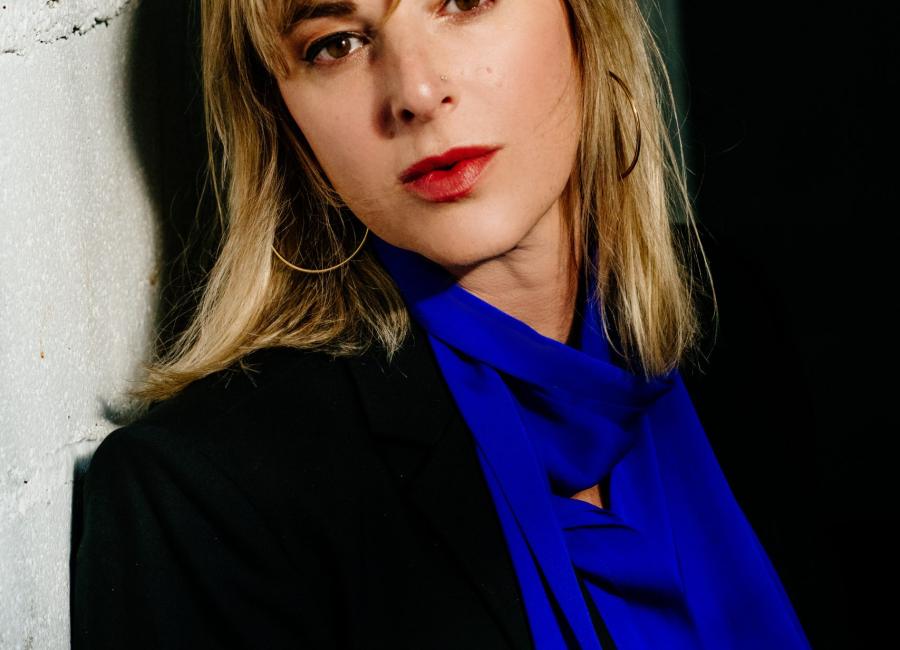 Photo of author leaning against a wall and looking at the camera.
