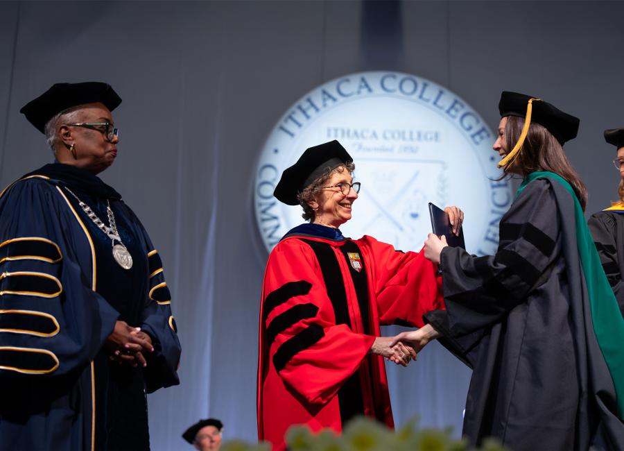 Female student receives her diploma cover