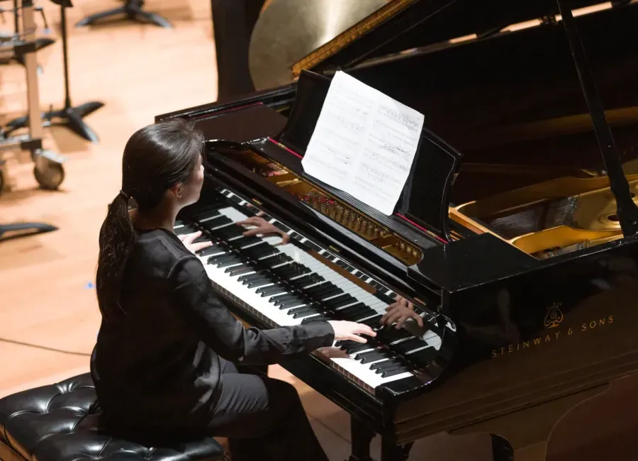 student playing a piano on stage