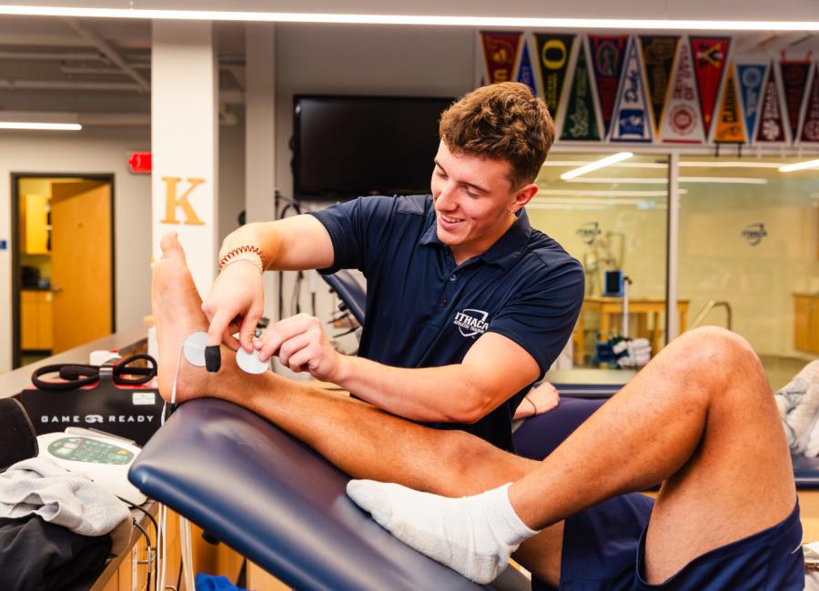 student places electrodes on another students ankle