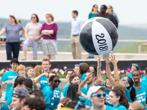 Students splash in a fountain and hit a beach ball in the year