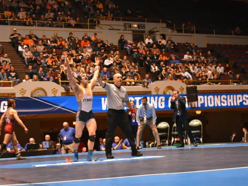 A referee holds up a wrestler's arm in victory