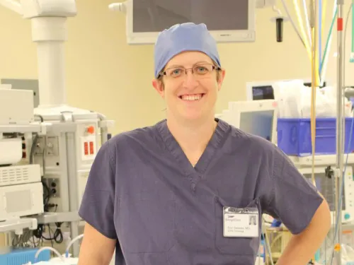 A woman in scrubs stands in a hospital room