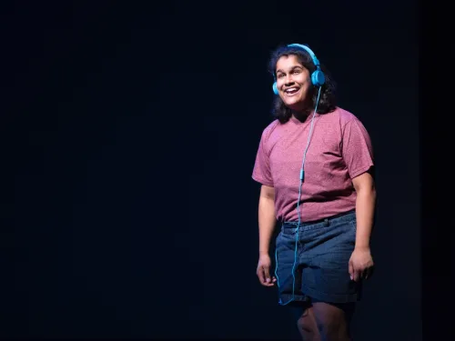 A person wearing headphones on a dark stage