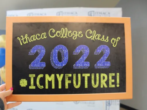 Handheld chalkboard that reads "Ithaca College Class of 2022 #icmyfututre!" 