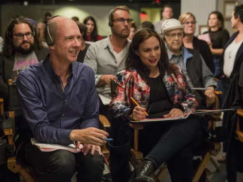 A man and woman sitting in director's chairs