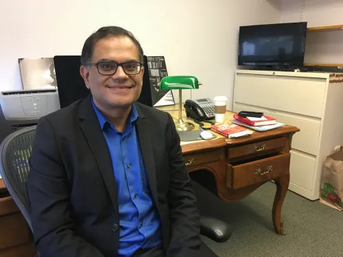 A man in a suit jacket sitting in an office