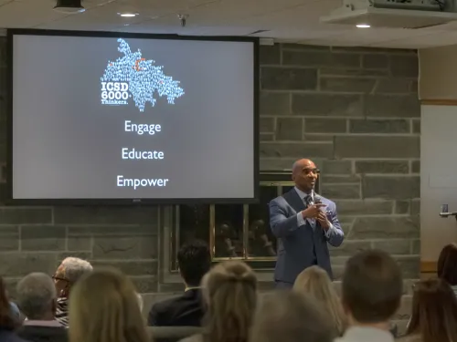A man gives a presentation in front of a screen