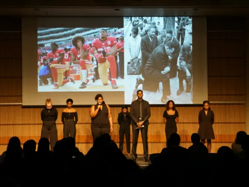 Young people wearing black standing on stage