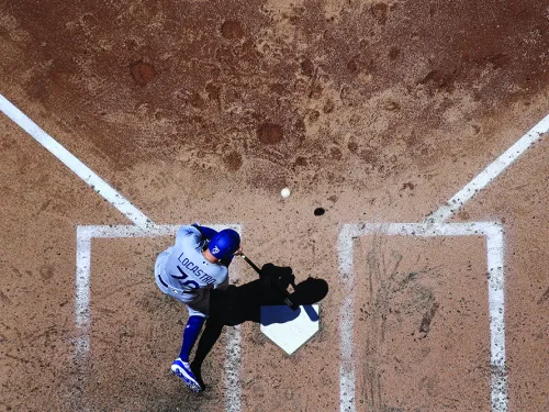 Baseball player hitting the ball from home plate from an aerial view