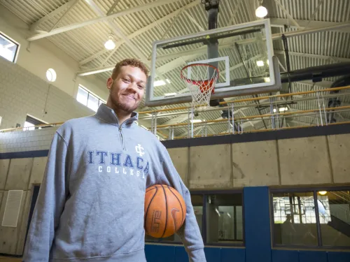 A man standing with a basketball on a basketball court
