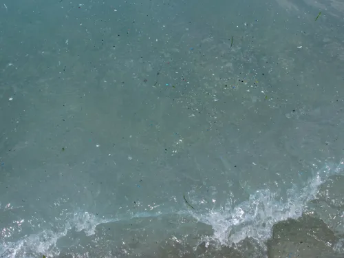 Small pieces of plastic in blue water