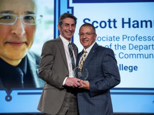 Two men holding an award