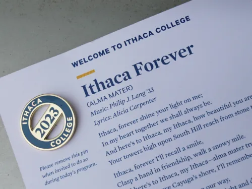 A Class of 2023 pin on a card with text