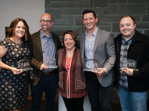 A group of men and women holding awards