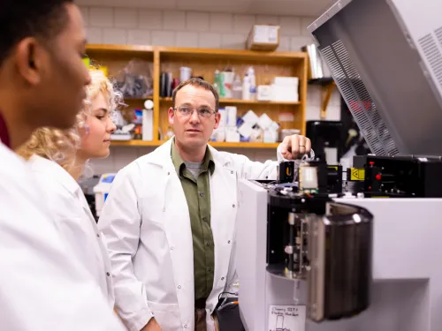 professor works with students in the lab