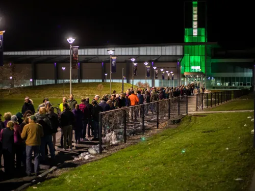 building at night with long line of people