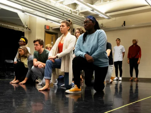 Young people kneeling in a rehearsal space