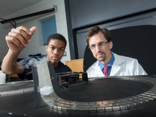 a male student and a male faculty member work on a research project
