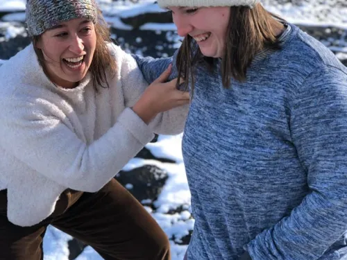 A group of two students are playing in the snow.