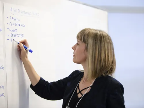 woman writing on a large sheet of paper