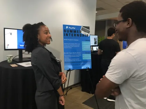 Two students talking in front of a sign that says student internships