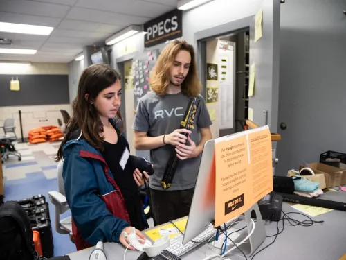 Two female students looking at video recording equipment