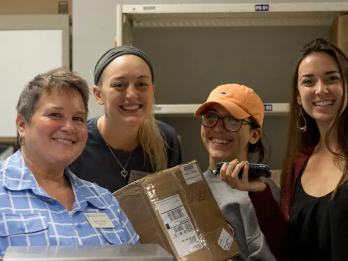 staff member with students in the mail office