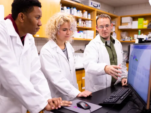 professor working with student in a science lab
