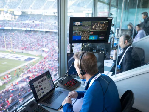man watches football game from control room