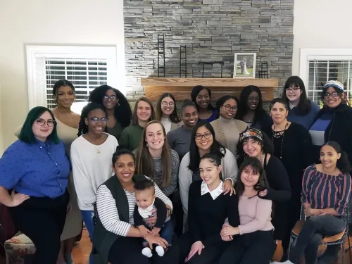 group of women in front of a fireplace